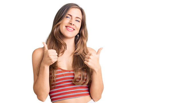 Beautiful caucasian young woman wearing casual clothes success sign doing positive gesture with hand, thumbs up smiling and happy. cheerful expression and winner gesture.