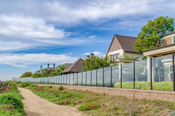 Fototapeta na wymiar Pathway along houses with glass fences in scenic Huntington Beach California