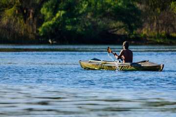 Young man kayaking on a river at summer