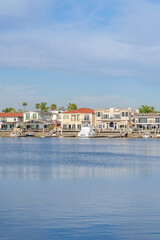 Fototapeta na wymiar Blue sea and waterfront homes against cloudy sky in Huntington Beach California