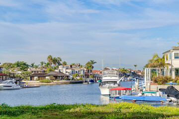 Fototapeta na wymiar Seaside city in Huntington Beach California with houses around water with boats