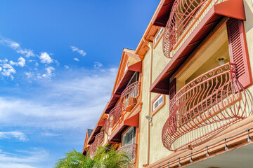Residential building with curved wrought iron railing on windows and balconies
