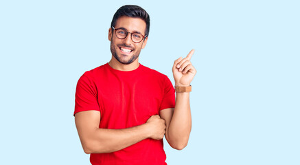 Fototapeta premium Young hispanic man wearing casual clothes and glasses smiling happy pointing with hand and finger to the side