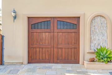 Brown wooden garage door with glass panes in Huntington Beach California