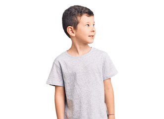 Cute blond kid wearing casual clothes looking away to side with smile on face, natural expression. laughing confident.