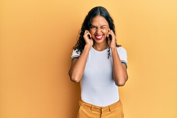 Young african american girl wearing casual clothes covering ears with fingers with annoyed expression for the noise of loud music. deaf concept.