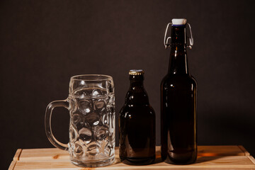 empty beer bottle on a wooden table and a glass of beer