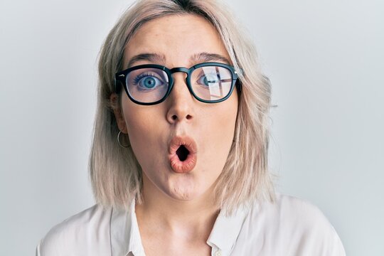 Young blonde girl wearing casual clothes and glasses scared and amazed with open mouth for surprise, disbelief face