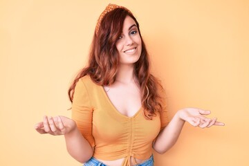 Young beautiful woman wearing casual clothes clueless and confused expression with arms and hands...