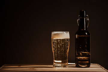 beer bottle on a wooden table and a glass of beer