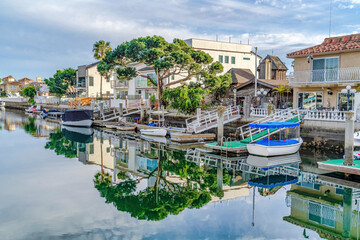 Fototapeta premium Water in Huntington Beach California harbour with reflection of trees and sky