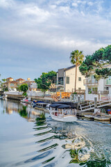 Fototapeta na wymiar Mirror like water in Huntington Beach CA with homes overlooking the harbour