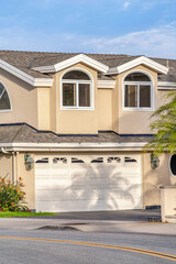 Home exterior with attached garage and dormers on gray roof in Huntington Beach