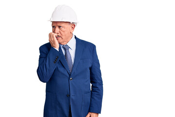Senior handsome grey-haired man wearing suit and architect hardhat looking stressed and nervous with hands on mouth biting nails. anxiety problem.