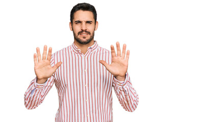Naklejka premium Young hispanic man wearing business shirt afraid and terrified with fear expression stop gesture with hands, shouting in shock. panic concept.
