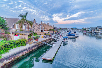 Fototapeta na wymiar Houses overlooking the picturesque sea with docks and boats in Huntington Beach