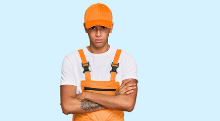 Young handsome african american man wearing handyman uniform skeptic and nervous, disapproving expression on face with crossed arms. negative person.