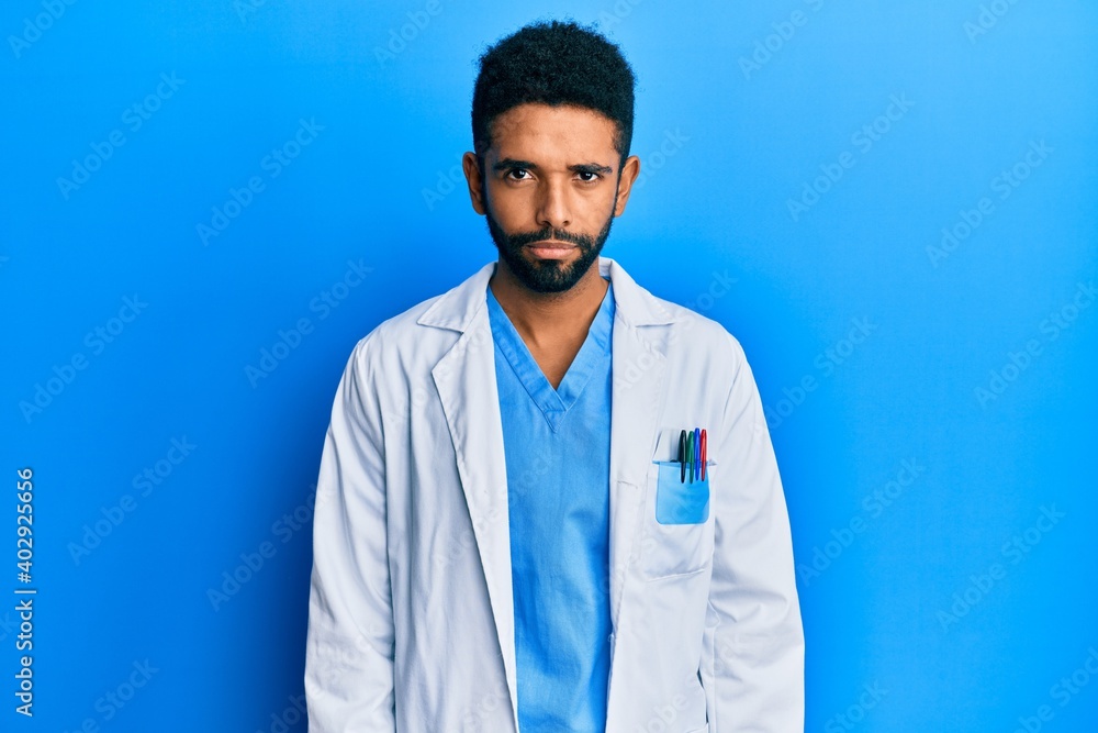 Wall mural Handsome hispanic man with beard wearing doctor uniform skeptic and nervous, frowning upset because of problem. negative person.