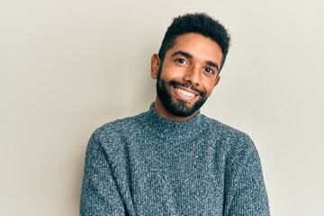 Fototapeta premium Handsome hispanic man with beard wearing casual clothes happy face smiling with crossed arms looking at the camera. positive person.