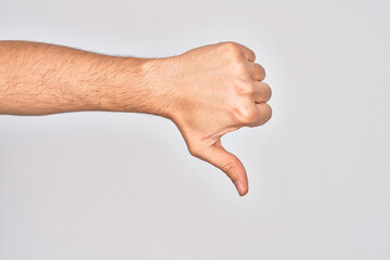 Hand of caucasian young man showing fingers over isolated white background doing thumbs down rejection gesture, disapproval dislike and negative sign