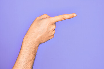 Hand of caucasian young man showing fingers over isolated purple background pointing with index finger to the side, suggesting and selecting a choice