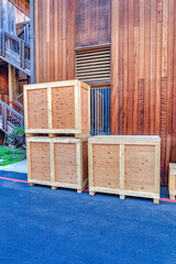 Crate boxes stacked against wooden exterior wall of building with vent window