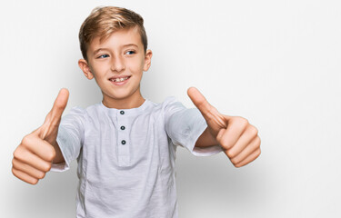 Little caucasian boy kid wearing casual clothes approving doing positive gesture with hand, thumbs up smiling and happy for success. winner gesture.