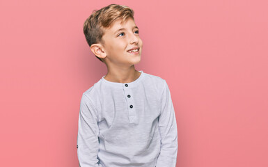 Little caucasian boy kid wearing casual clothes looking away to side with smile on face, natural...