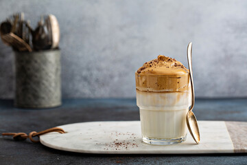 Dalgona coffee or whipped instant coffee. New popular food and drink trend. Light background, one glass with copy space