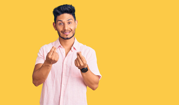 Handsome latin american young man wearing casual summer shirt doing money gesture with hands, asking for salary payment, millionaire business