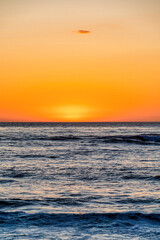 Shimmering sea and setting sun against the orange sky in San Diego CA sunset