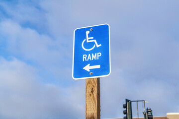 Wheelchair Ramp with arrow sign against cloudy blue sky in San Diego California
