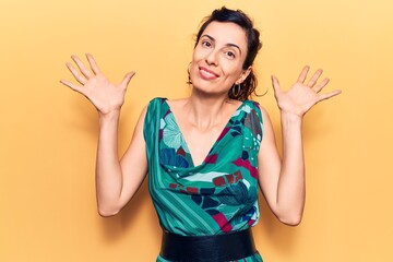 Young beautiful hispanic woman wearing casual clothes clueless and confused with open arms, no idea...
