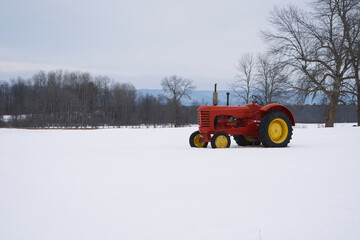 A red tractor in a snow filled farmers field © Joe