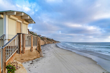 Beach house overlooking the ocean and cloudy blue sky in San Diego California - Powered by Adobe