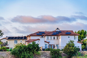 House with solar panels on red tile roof over white wall in San Diego California