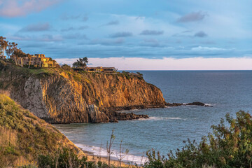 Fototapeta na wymiar Laguna Beach California scenery with house on cliff overlooking the blue ocean