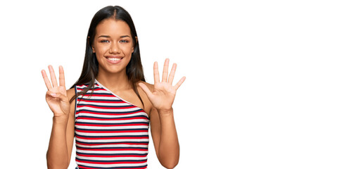 Beautiful hispanic woman wearing casual clothes showing and pointing up with fingers number eight while smiling confident and happy.