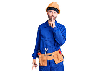 Young hispanic man wearing worker uniform asking to be quiet with finger on lips. silence and secret concept.