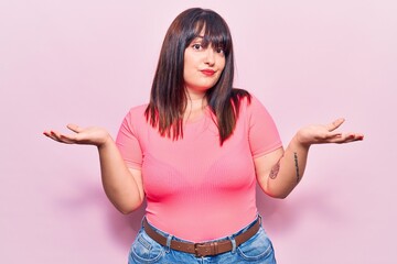 Young plus size woman wearing casual clothes clueless and confused expression with arms and hands...