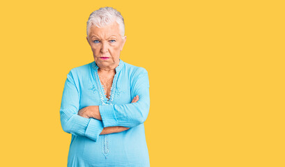 Senior beautiful woman with blue eyes and grey hair wearing summer dress skeptic and nervous,...