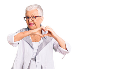 Senior beautiful woman with blue eyes and grey hair wearing casual clothes and glasses smiling in love doing heart symbol shape with hands. romantic concept.
