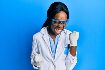 Young african american woman wearing scientist uniform celebrating surprised and amazed for success...