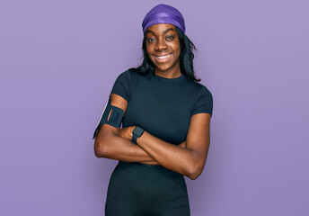 Young african american woman wearing sportswear happy face smiling with crossed arms looking at the camera. positive person.