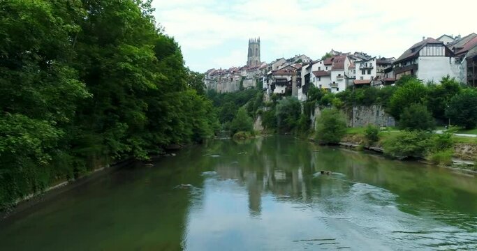 Drone aerial over river in fribourg Switzerland revealing castle and village