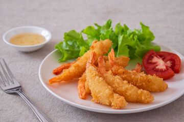 Fried breaded shrimp with vegetable on plate and plum sauce