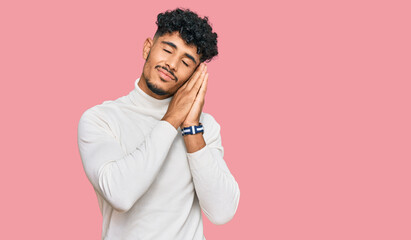 Young arab man wearing casual winter sweater sleeping tired dreaming and posing with hands together while smiling with closed eyes.