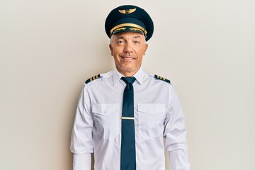 Handsome middle age mature man wearing airplane pilot uniform with a happy and cool smile on face. lucky person.
