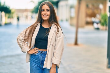 Young hispanic girl smiling happy standing at the city.