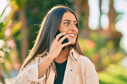 Young hispanic girl smiling happy talking on the smartphone at the park.